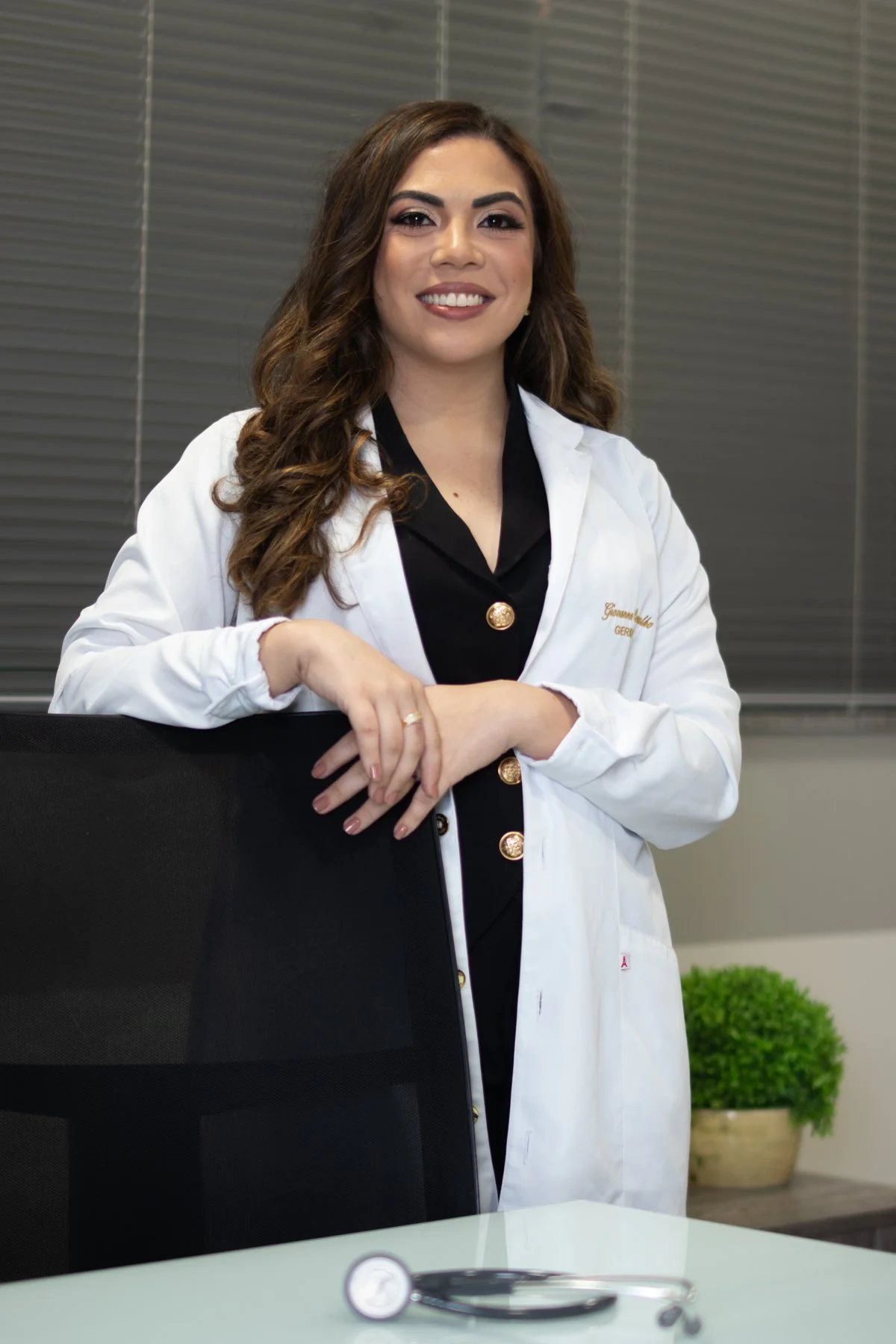 Dra. Giovanna Carvalho sorrindo, de jaleco branco, no consultório.